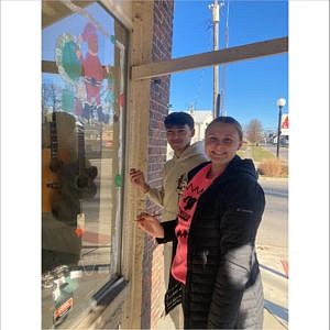Hauser students MiKenze Bostic and Cameron Blair painting windows on the square for the holidays. December 14, 2023.