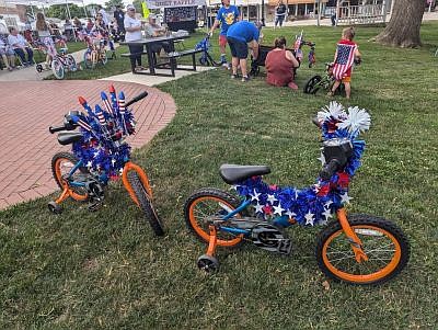 Decorated bikes lined up for the bike parade Friday evening, June 28, 2024, during the Old-Fashioned Independence Day celebration, hosted by the Yellow Trail Museum, on the Hope Town Square in downtown Hope, Ind. Photo credit: Susan Thayer-Fye.