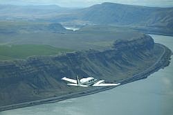Jill Baker flying the Twin Comanche down the Snake River through the
Palouse Region of Eastern Washington State. June 12, 2004. Photo credit: Mike Harding.